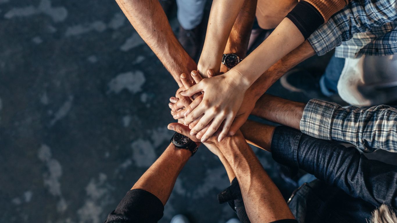 A group placing their hands together as a sign of teamwork